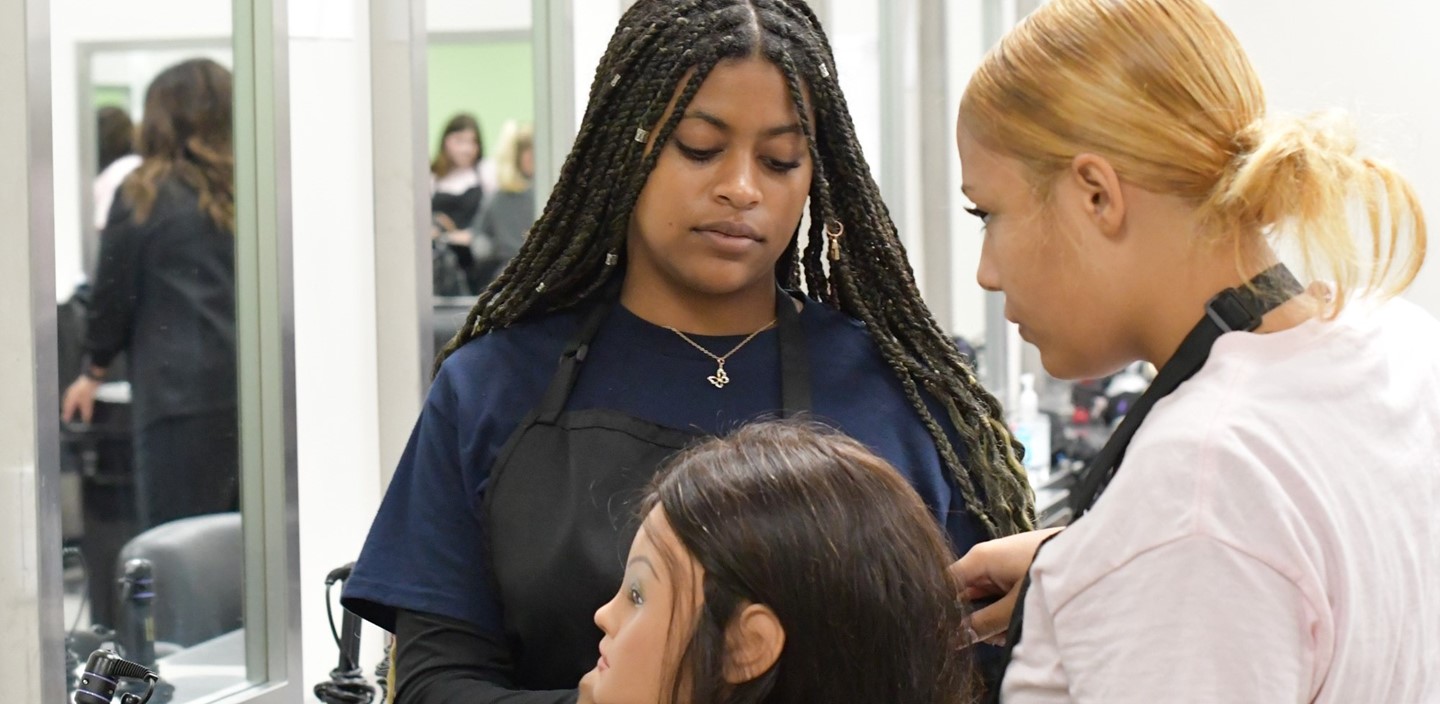 Cosmetology students working on mannequin