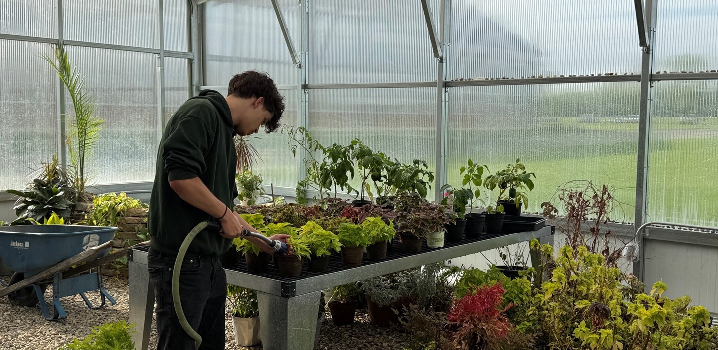 Natural Resource Tech Student Watering Plants
